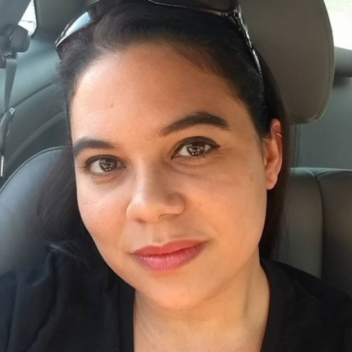 Liz smiling at the camera in the passenger seat of a car.